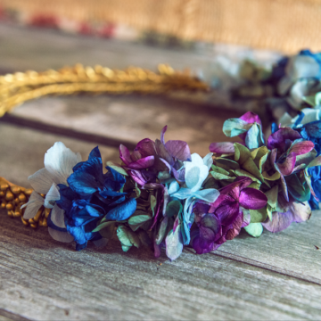 corona de flores preservadas azules, verdes y malva y pistilos dorados